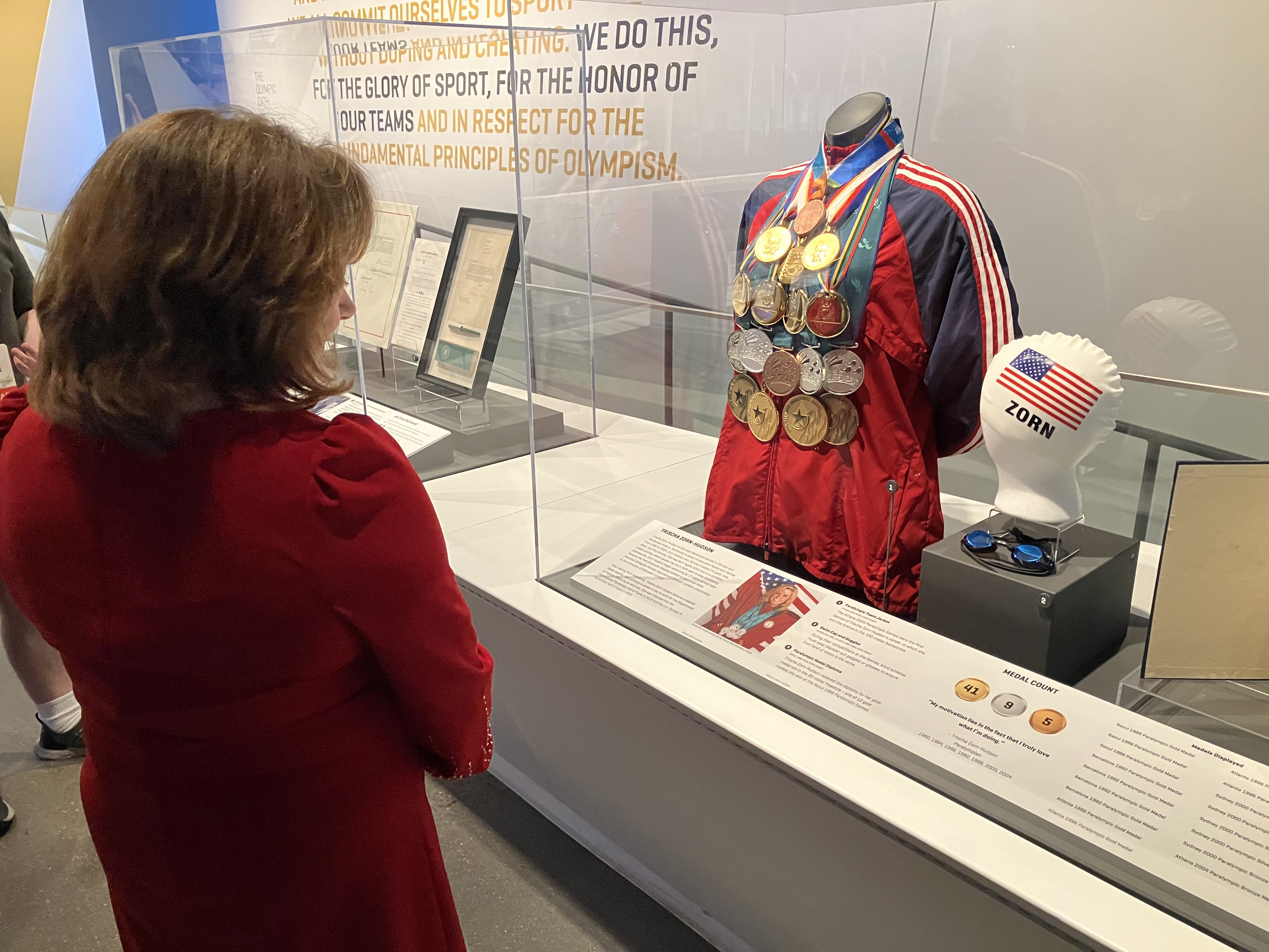Lt. Governor Primavera looks at a display case of medals won by Paralympian Trischa Zorn-Hudson.